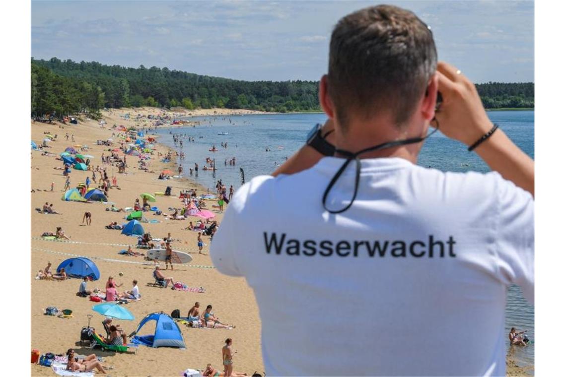 Hitze in Deutschland bringt möglicherweise Temperaturrekord Gut aufpassen: Ein Rettungsschwimmer vom Deutschen Roten Kreuz beobachtet die Badegäste im Wasser des Helenesees in Frankfurt/Oder. Foto: Patrick Pleul