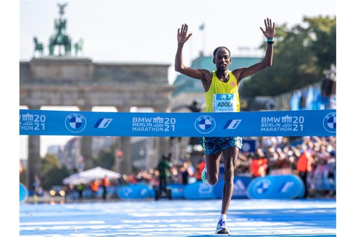 Guye Adola aus Äthiopien läuft beim Berlin Marathon nach 2:05:45 Stunden als Erster durchs Ziel. Foto: Andreas Gora/dpa