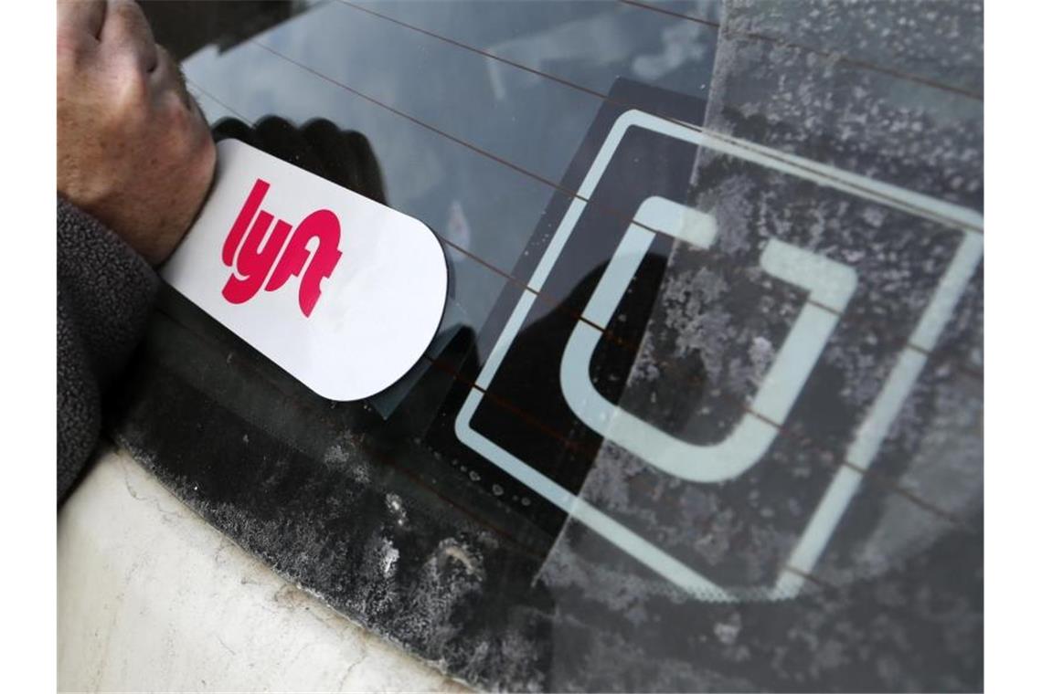 Haben Streit um den rechtlichen Status von Fahrern: die Fahrdienst-Vermittler Uber und Lyft. Foto: Gene J. Puskar/AP/dpa