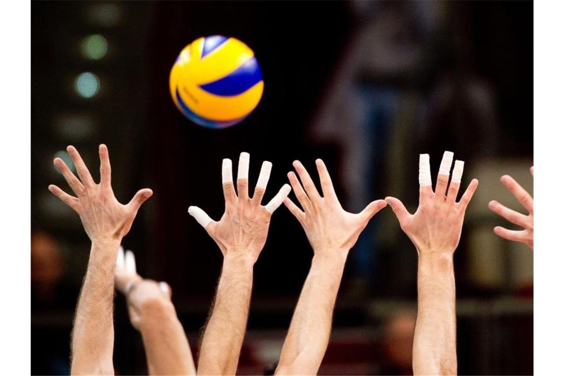 Hände greifen während eines Spiels nach dem Volleyball. Foto: Sebastian Kahnert/Archivbild