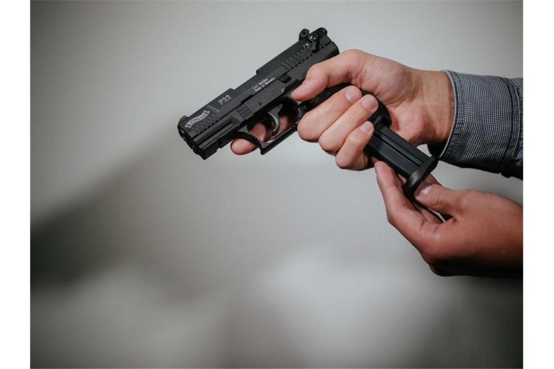 Imbiss-Besitzer mit vorgehaltener Pistole überfallen Hände laden eine Schreckschuss-Pistole "Walther P22" mit einem Magazin. Foto: Oliver Killig/Archivbild