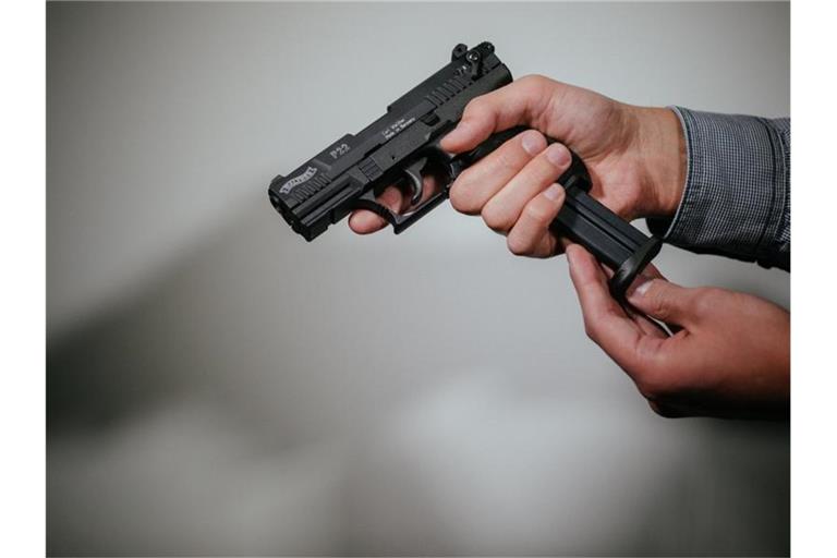 Hände laden eine Schreckschuss-Pistole "Walther P22" mit einem Magazin. Foto: Oliver Killig/Archivbild