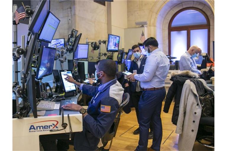 Händler arbeiten auf dem Parkett der New Yorker Börse an der Wall Street. Foto: Ted Shaffrey/AP/dpa