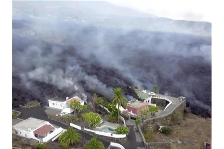 Häuser an einem Hang werden von Lava zerstört. Erstmals seit 50 Jahren ist auf der spanischen Kanareninsel La Palma wieder ein Vulkan ausgebrochen. Foto: Uncredited/OVERON/dpa