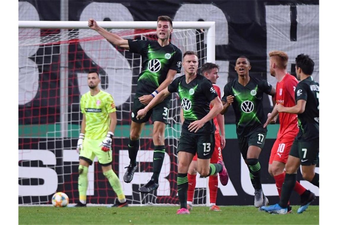 Halle-Keeper Kai Eisele (l-r) ist geschlagen, Wolfsburgs Robin Knoche feiert sein Tor zum 4:3. Foto: Hendrik Schmidt