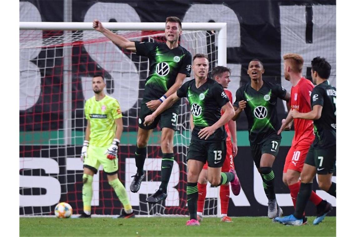 Zittersieg nach Verlängerung: Wolfsburg entgeht Blamage Halle-Keeper Kai Eisele (l-r) ist geschlagen, Wolfsburgs Robin Knoche feiert sein Tor zum 4:3. Foto: Hendrik Schmidt