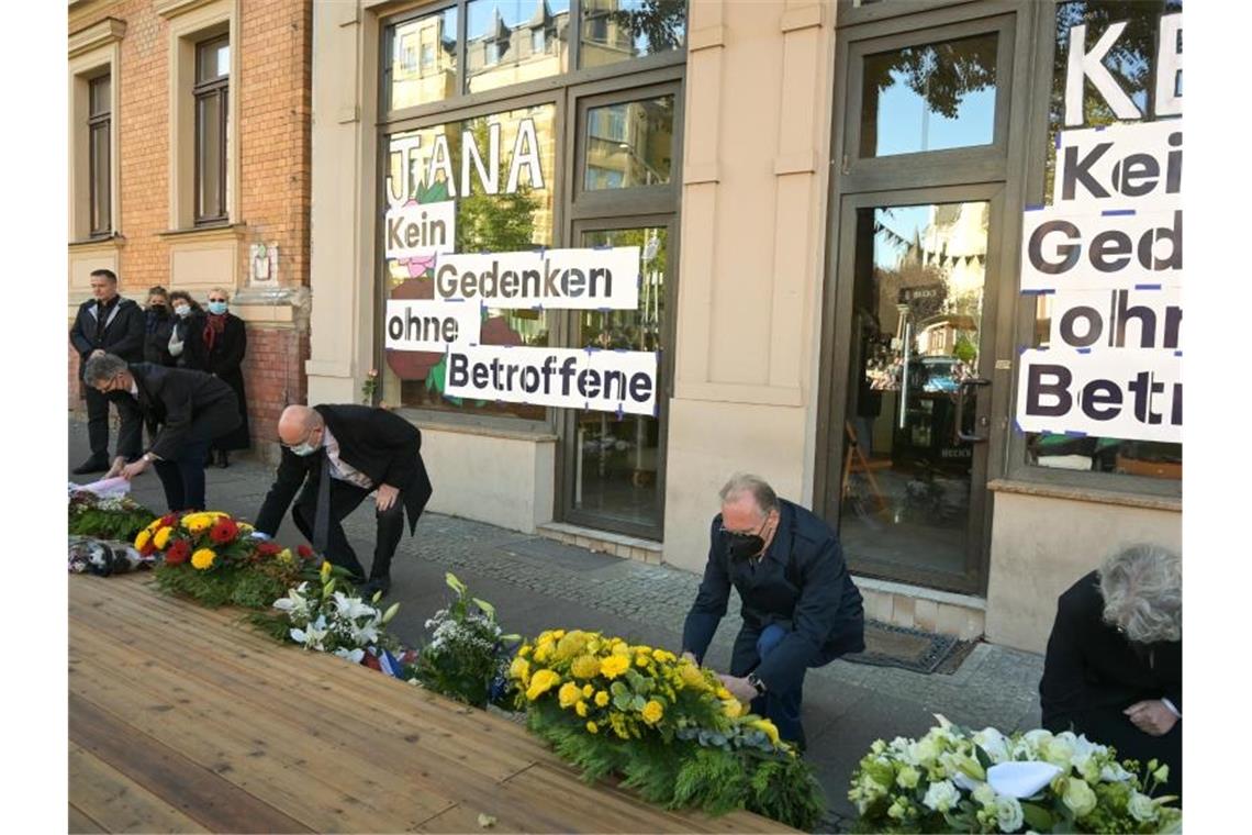 Halles Bürgermeister Egbert Geier (SPD, l) und Sachsen-Anhalts Ministerpräsident Reiner Haseloff (CDU, M) legen vor einem der Tatorte, einem Döner-Imbiss, Kränze für die Opfer des Anschlags vor zwei Jahren nieder. Foto: Heiko Rebsch/dpa / Zentralbild/dpa