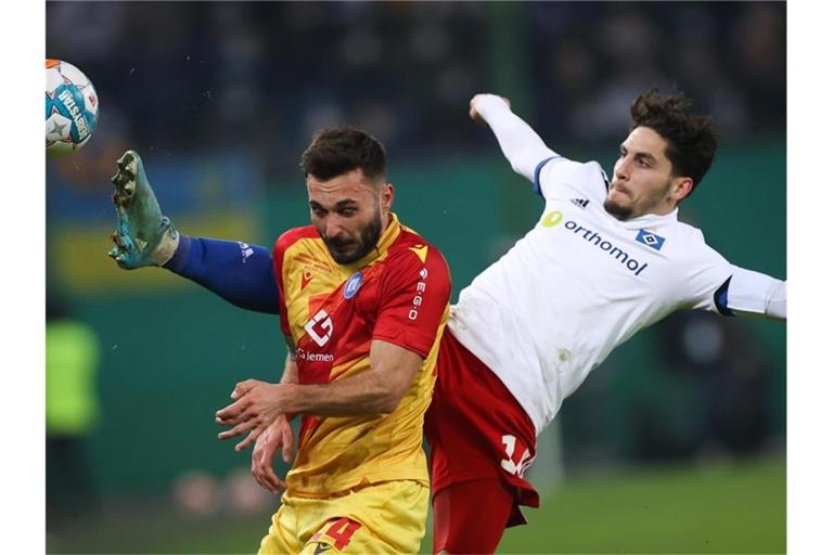 Hamburgs Ludovit Reis und Karlsruhes Fabian Schleusener (l) im Kampf um den Ball. Foto: Christian Charisius/dpa
