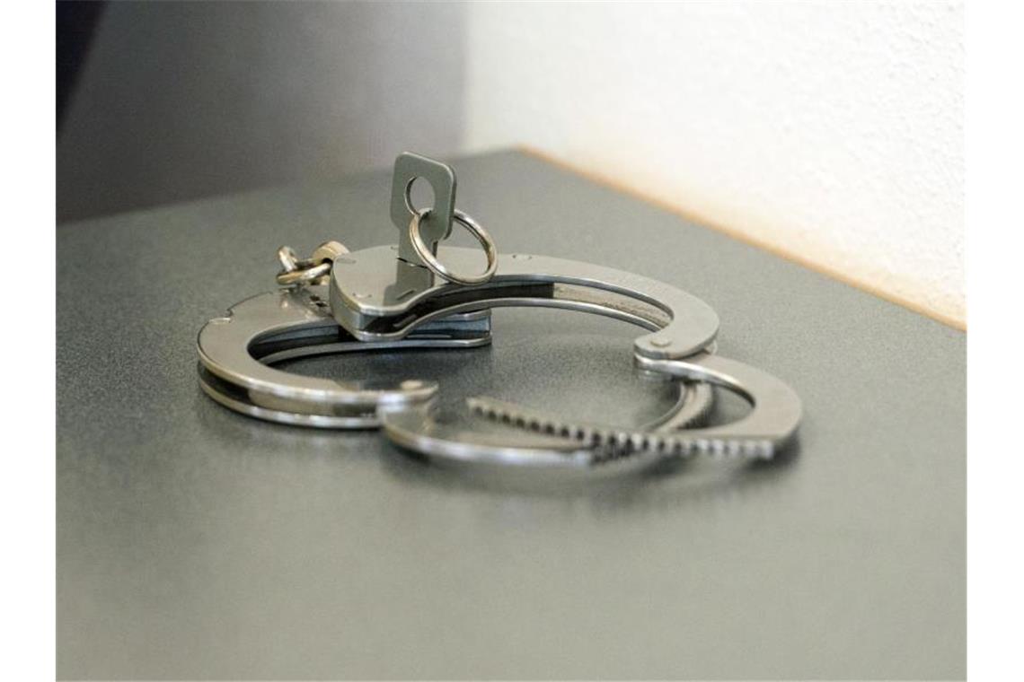 Katalysatoren aus Autos gestohlen: Verdächtige in U-Haft Handschellen liegen auf einem Tisch. Foto: Armin Weigel/dpa/Symbolbild