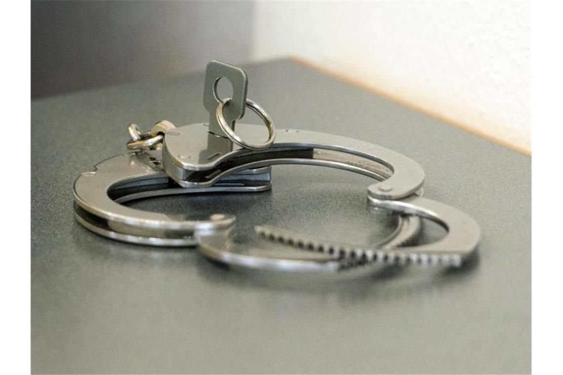 Nach Angriff auf Ehefrau und Söhne kommt Mann in U-Haft Handschellen liegen auf einem Tisch. Foto: Armin Weigel/dpa/Archivbild