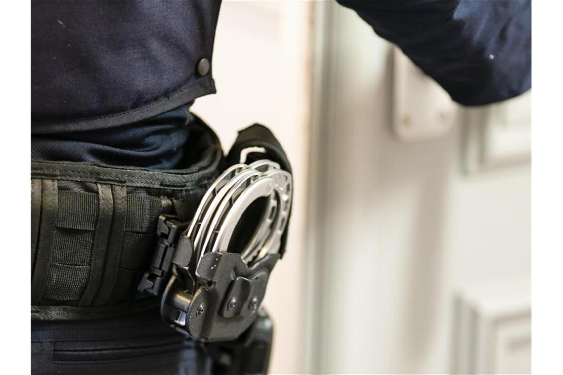 Handschellen sind an einem Gürtel eines Justizvollzugsbeamten befestigt. Foto: Frank Molter/dpa/Archivbild