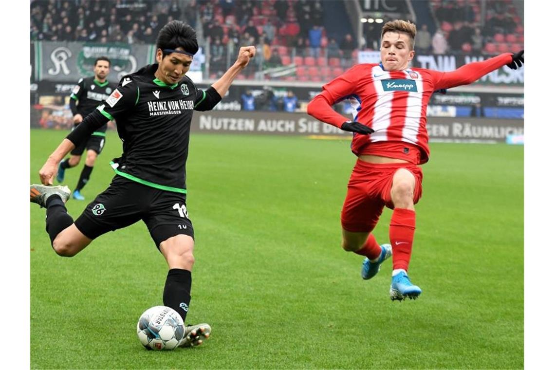 Hannovers Genki Haraguchi (l.) und Heidenheims David Otto kämpfen um den Ball. Foto: Stefan Puchner/dpa