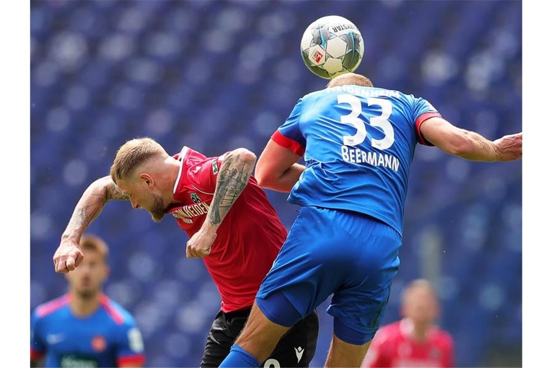 Rückschlag für Heidenheim im Aufstiegsrennen: H96 siegt 2:1 Hannovers John Guidetti (l) in Aktion gegen Heidenheims Timo Beermann. Foto: Friedemann Vogel/epa/Pool/dpa