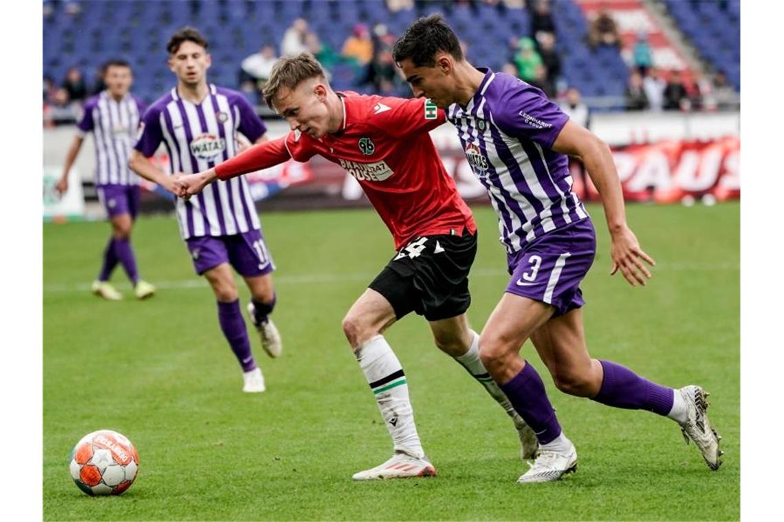 Pauli weiterhin Tabellenführer - Sandhausen schlägt Dresden Hannovers Maximilian Beier (l) im Zweikampf mit Aues Dirk Carlson. Foto: Axel Heimken/dpa
