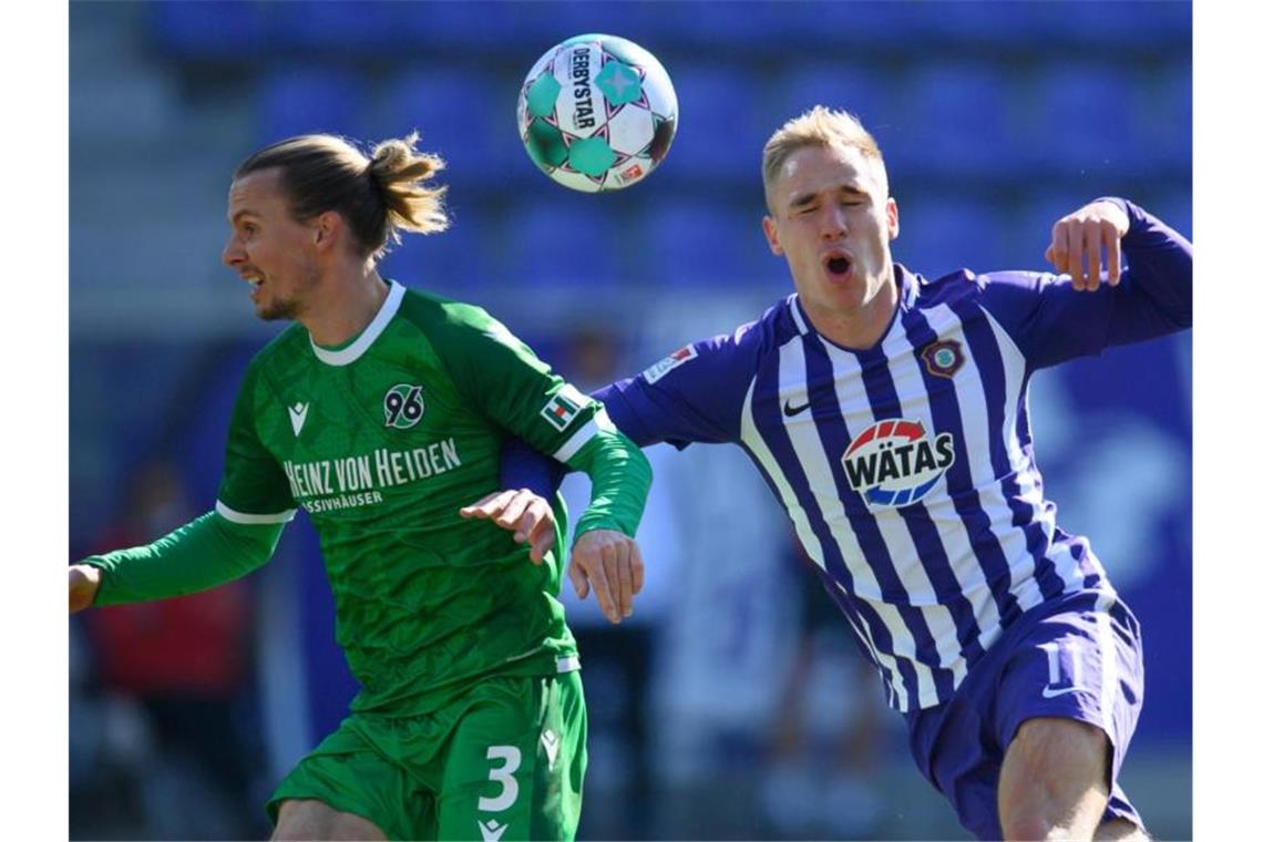VfL Bochum siegt im Spitzenspiel und setzt sich etwas ab Hannovers Niklas Hult (l) im Zweikampf mit Aues Florian Krüger. Foto: Robert Michael/dpa-Zentralbild/dpa