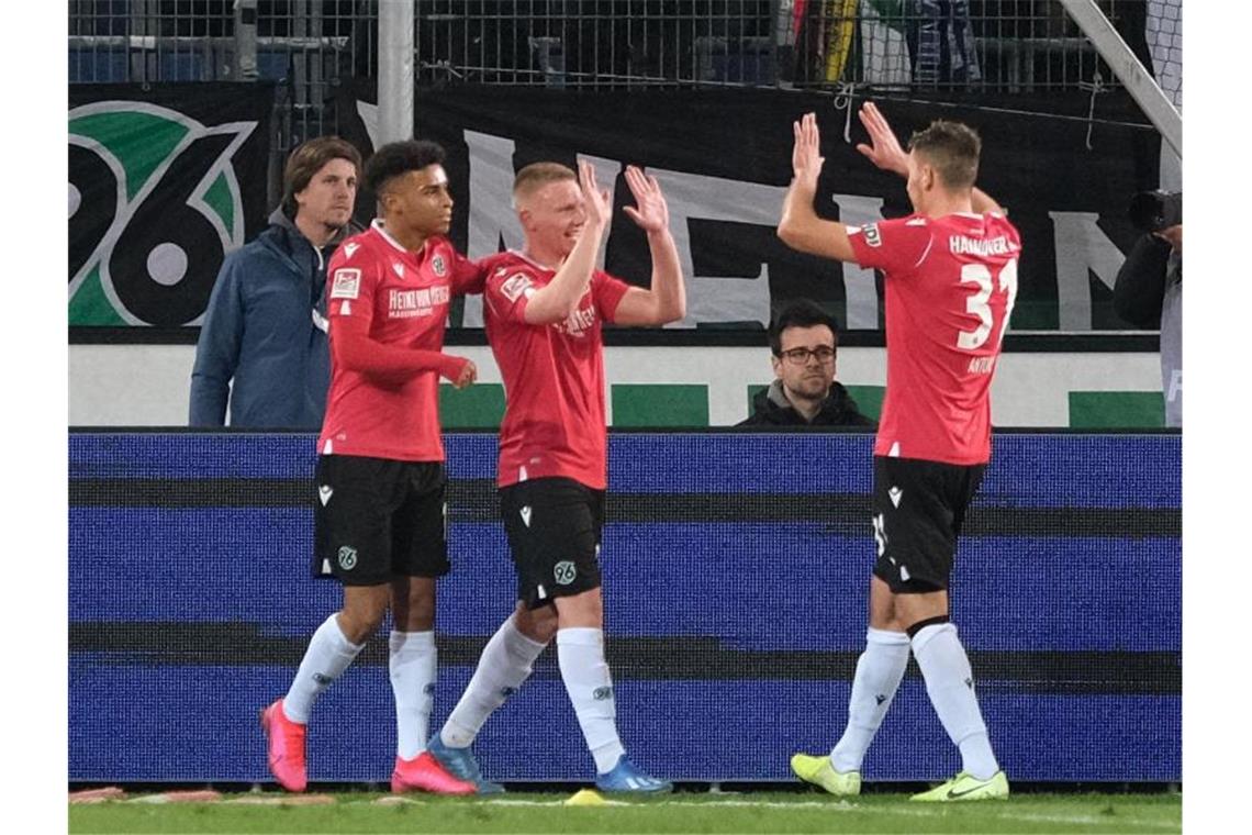 Hannovers Philipp Ochs (M) bejubelt sein Tor zum 2:1 gegen Holstein Kiel mit Linton Maina und Waldemar Anton (r). Foto: Peter Steffen/dpa