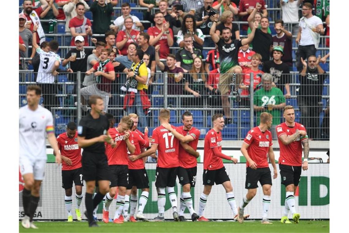 Bremen feiert nächsten Sieg - Späte Tore in Karlsruhe Hannovers Spieler jubeln über das 1:0 gegen den FC St. Pauli. Foto: Swen Pförtner/dpa