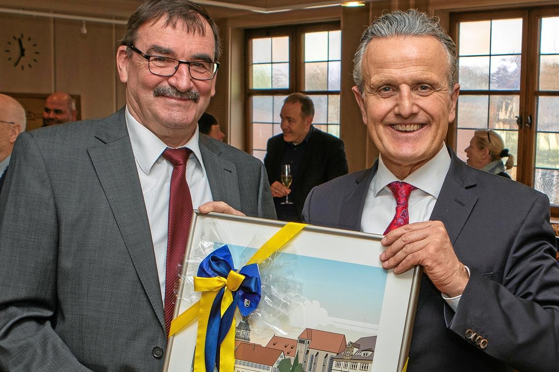 Hans Bruss erhielt von Oberbürgermeister Frank Nopper (rechts) ein Werk von Hellmut G. Bomm. Es zeigt den Blick auf den Backnanger Stiftshof aus fast genau der Perspektive, die auch der Amtsleiter aus seinem Zimmer in den vergangenen Jahren hatte. Foto: A. Becher