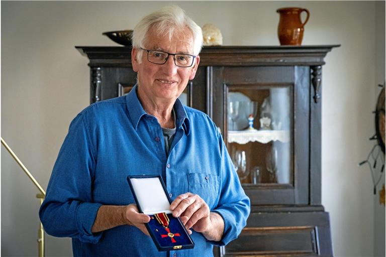 Hans-Peter Müller zeigt das Bundesverdienstkreuz, das ihm verliehen worden ist. Foto: A. Becher