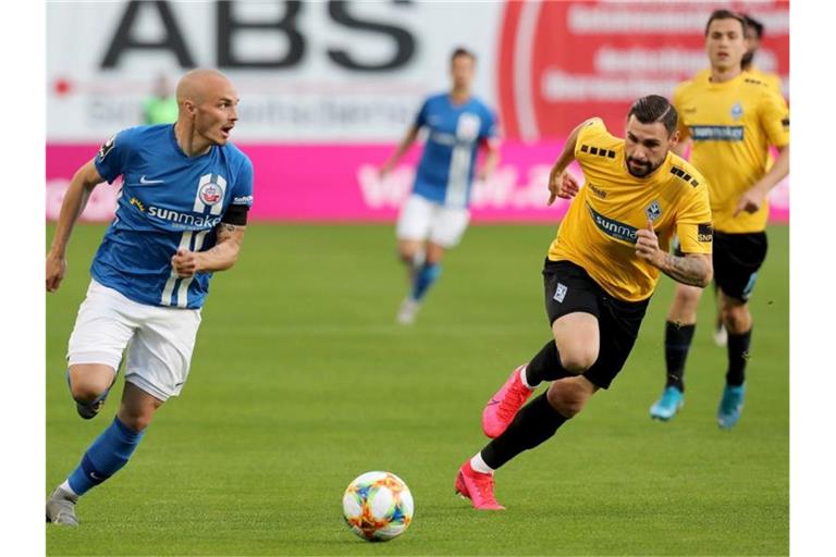 Hansa-Spieler Korbinian Vollmann (l-r) und der Mannheimer Marcel Hofrath im Zweikampf. Foto: Bernd Wüstneck/dpa-Zentralbild/dpa