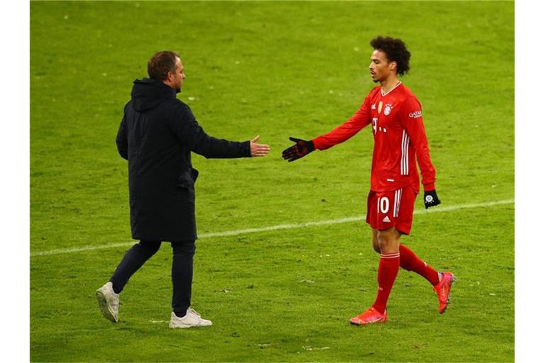 Hansi Flick (l) bedankt sich nach dem Spiel bei Leroy Sane. Foto: Adam Pretty/Getty Images Europe/Pool/dpa