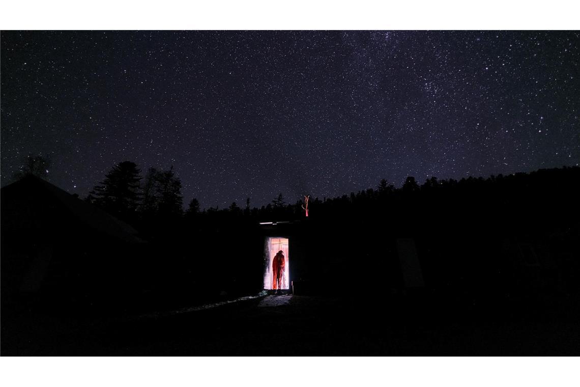 Forschung extrem: Schwarzlicht-Frösche und eisige Einsamkeit Hao-Cheng Yu geht unter einem spektakulären Sternenhimmel in die Hütte, die er während seiner Forschungen bewohnte.