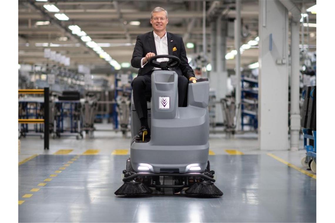 Hartmut Jenner, Vorsitzender des Vorstands der Alfred Kärcher SE & Co. KG, in einer Werkshalle auf einer Scheuersaugmaschine. Foto: Marijan Murat/dpa