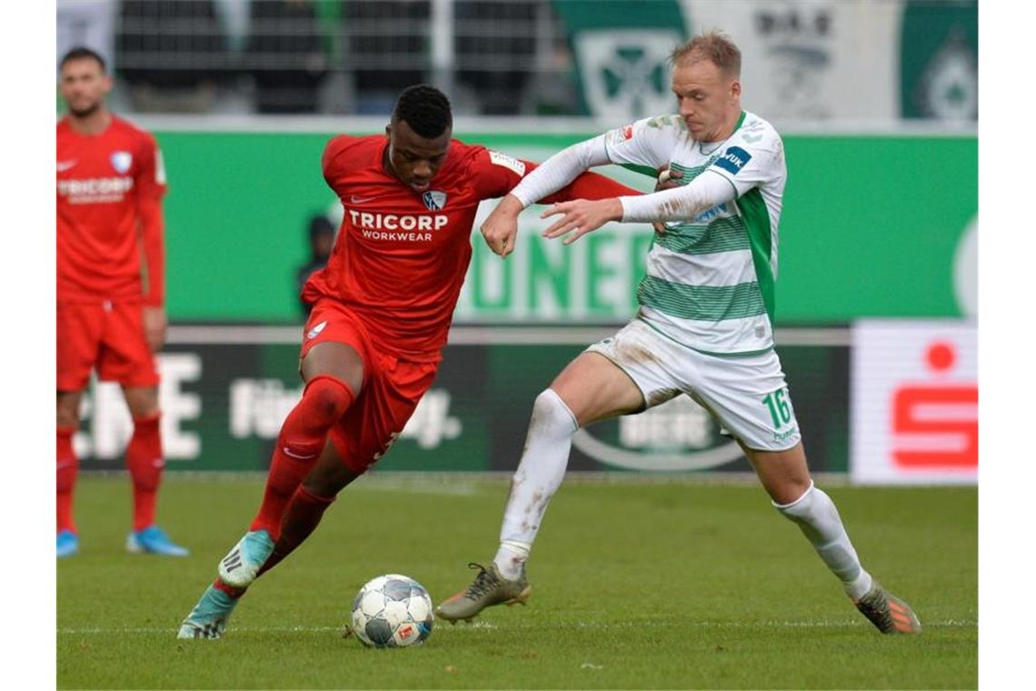 Harvard Nielsen von der SpVgg Greuther Fürth kämpft gegen Bochums Armel Bella Kotchap (l) um den Ball. Foto: Timm Schamberger/dpa