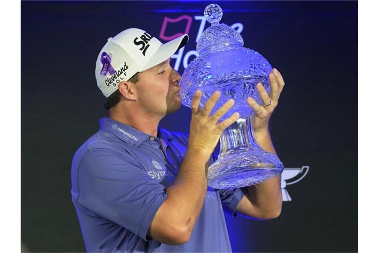 Hat als erster österreichischer Golf-Profi ein Turnier auf der PGA-Tour gewonnen: Sepp Straka feiert seinen Sieg und küsst die Trophäe. Foto: Marta Lavandier/AP/dpa