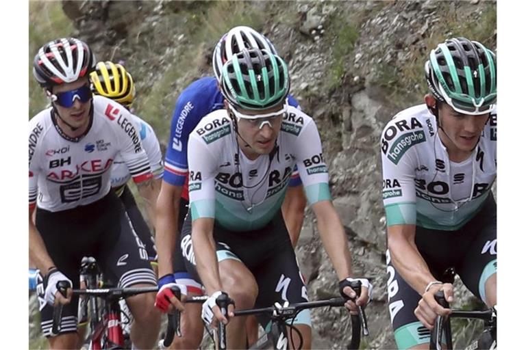 Hat seine Teamkameraden mit einer fehlerlosen Tour-Leistung beeindruckt: Emanuel Buchmann (M) vom Team Bora-hansgrohe. Foto: Thibault Camus/AP