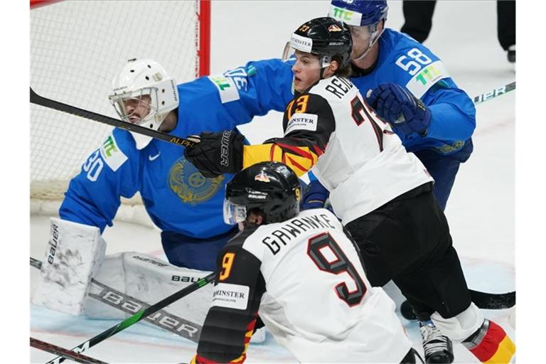 Hat umkämpftes Match: Deutschlands Leon Gawanke (9) und Lukas Reichel vor dem kasachischen Tor. Foto: Roman Koksarov/dpa