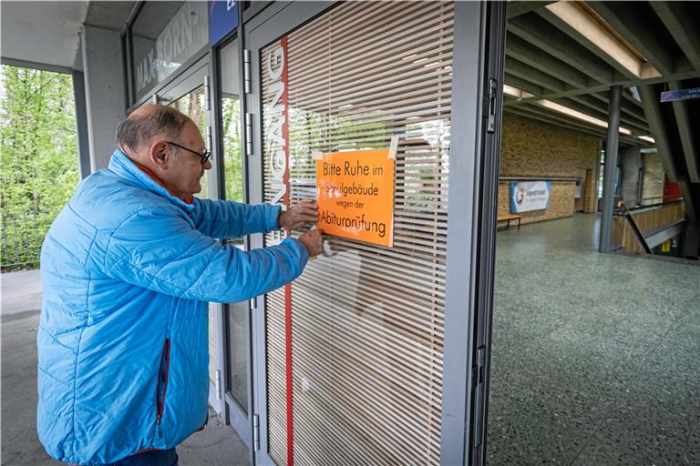 Hausmeister Stanislav Gaida hängt vor den Abiturprüfungen „Bitte Ruhe“-Schilder am Max-Born-Gymnasium auf. Foto: Alexander Becher