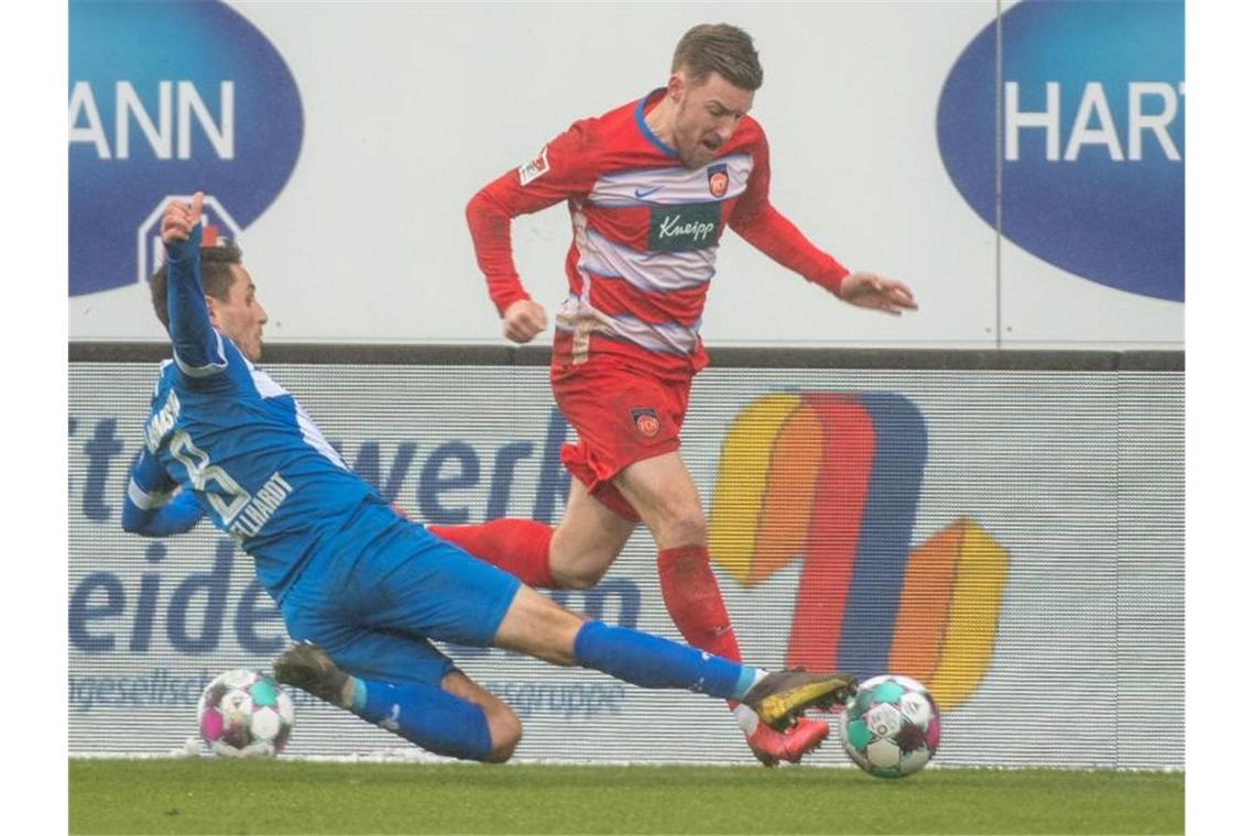 Heidenheims Christian Kühlwetter und Darmstadts Fabian Schnellhardt kämpfen um den Ball. Foto: Stefan Puchner/dpa