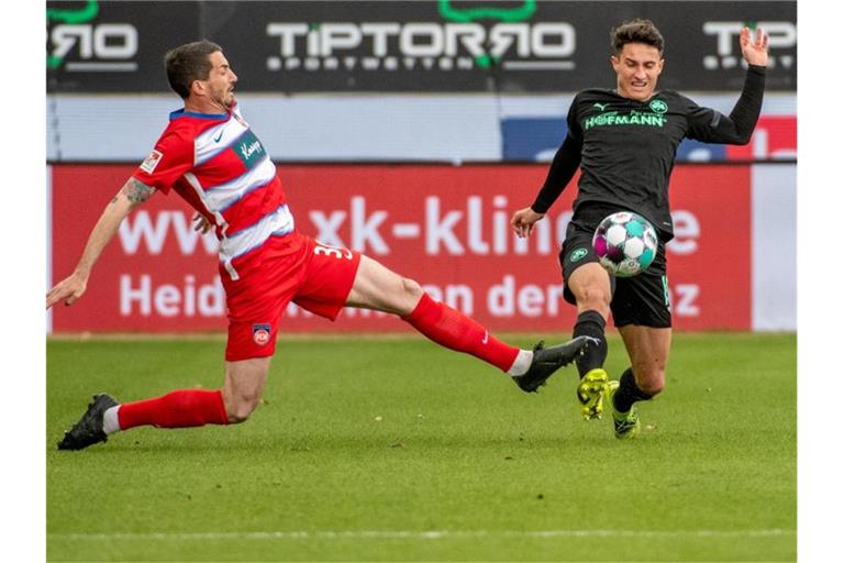 Heidenheims Norman Theuerkauf (l) und Fürths Marco Meyerhöfer kämpfen um den Ball. Foto: Stefan Puchner/dpa/Archivbild