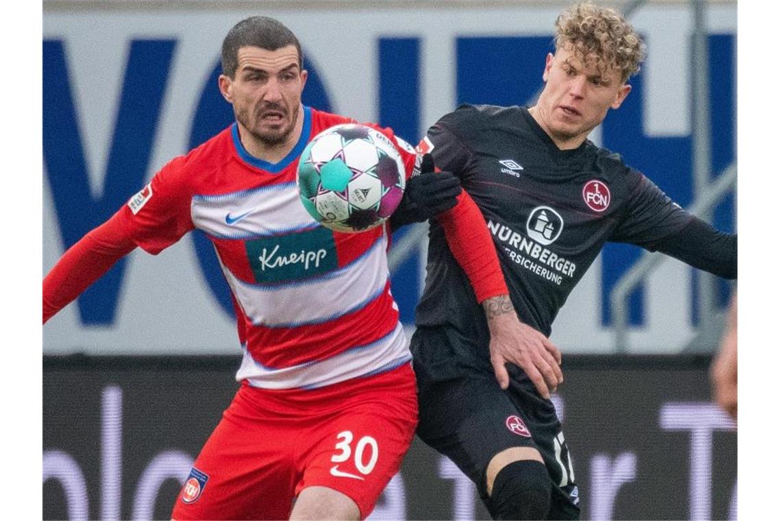Adduktorenverletzung: Theuerkauf droht Saison-Aus Heidenheims Norman Theuerkauf (l) und Nürnbergs Robin Hack kämpfen um den Ball. Foto: Stefan Puchner/dpa/Archivbild