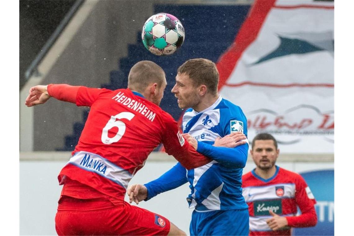 Heidenheims Patrick Mainka (l) und Darmstadts Felix Platte sind im Kopfballduell. Foto: Stefan Puchner/dpa