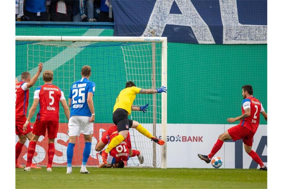 Heidenheims Torhüter Kevin Müller (2.v.r.) kann das 1:1-Ausgleichstor des FC Hansa Rostock nicht verhindern. Foto: Jens Büttner/dpa-Zentralbild/dpa