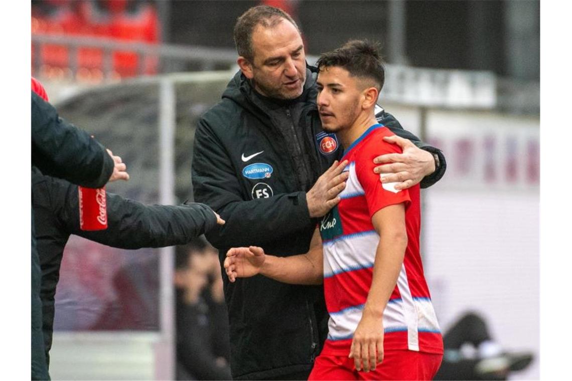 Heidenheims Trainer Frank Schmidt spricht mit Kevin Sessa (r). Foto: Stefan Puchner/dpa