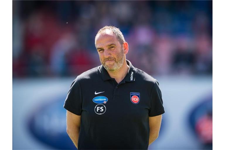 Heidenheims Trainer Frank Schmidt steht vor Spielbeginn auf dem Rasen. Foto: Christoph Schmidt/Archiv