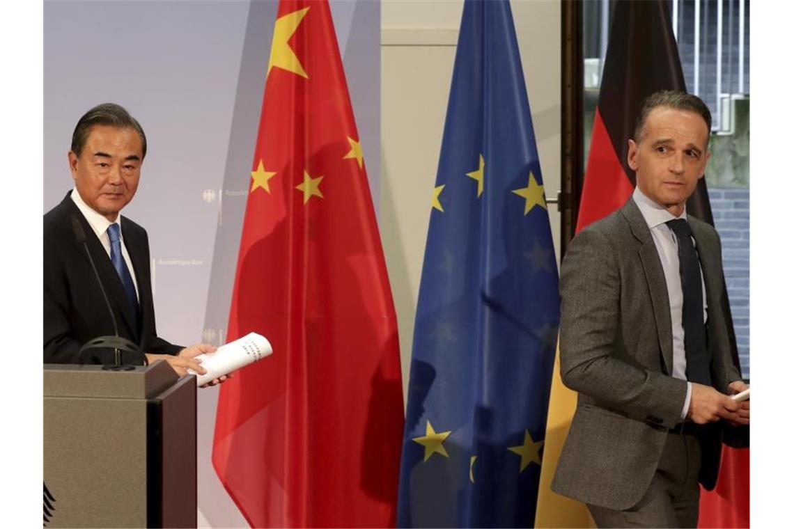 Heiko Maas und Wang Yi verlassen die Pressekonferenz, die mit 50 Minuten ungewöhnlich lange dauerte. Foto: Michael Sohn/AP pool/dpa