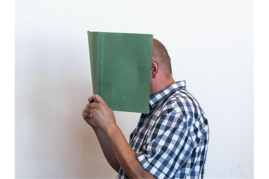 Staatsanwälte legen Revision gegen erstes Lügde-Urteil ein Heiko V. verbirgt im Landgericht sein Gesicht hinter einer Aktenmappe. Der 49-Jährige erhielt eine Bewährungsstrafe. Foto: Bernd Thissen