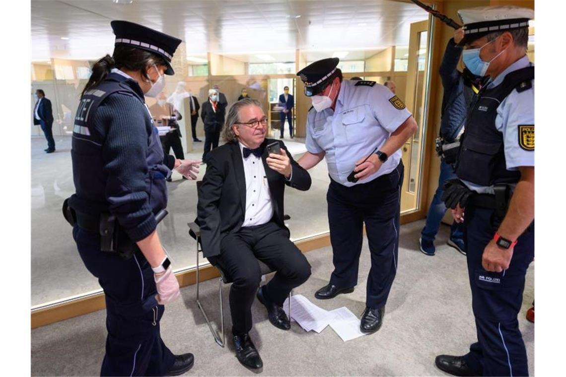 Polizeieinsatz im Plenum: Fiechtner fliegt aus dem Landtag Heinrich Fiechtner (M), fraktionsloser Abgeordneter, lässt sich von Polizisten aufhelfen. Foto: Sebastian Gollnow/dpa