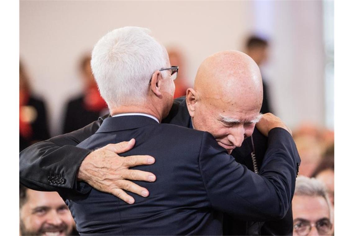 Friedenspreis für Fotograf Sebastião Salgado Heinrich Riethmüller (l), Vorsteher des Börsenvereins des Deutschen Buchhandels, umarmt Sebastião Salgado nach seiner Rede in der Paulskirche. Foto: Andreas Arnold/dpa