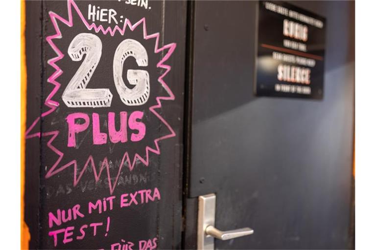 Heinweis auf 2G plus bei einer Bar in der Nürnberger Innenstadt. Foto: Daniel Karmann/dpa