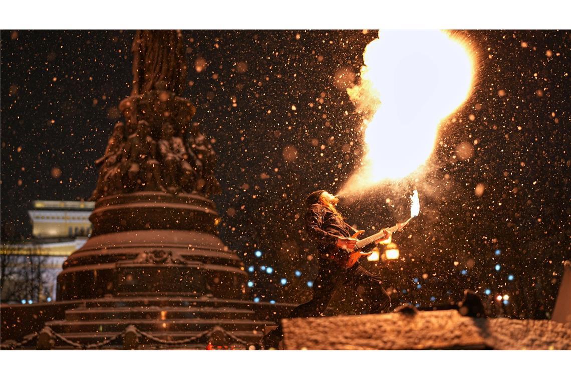 Heiß und kalt: Ein Straßenkünstler führt bei Schneefall eine Feuershow im russischen St. Petersburg auf.