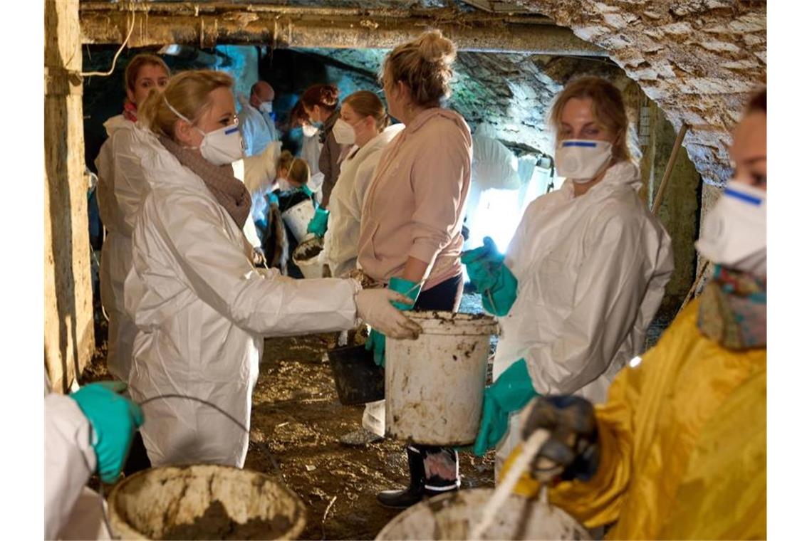 Ahrtal kämpft noch lange mit tödlicher Flut Helfer befreien ein Haus von Schlamm. Foto: Thomas Frey/dpa