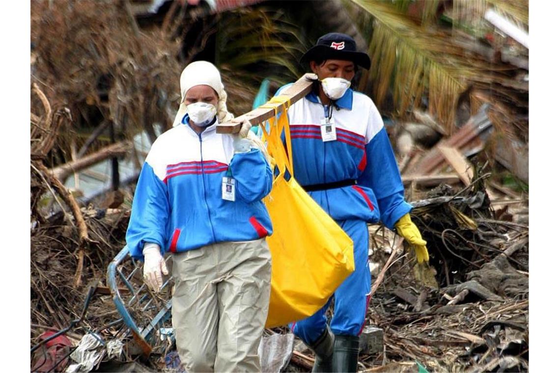Gebete für Opfer am 15. Jahrestag der Tsunami-Katastrophe Helfer bergen in Banda Aceh die Leiche eines Tsunami-Opfers. Foto: epa Nani Afrida/epa/dpa