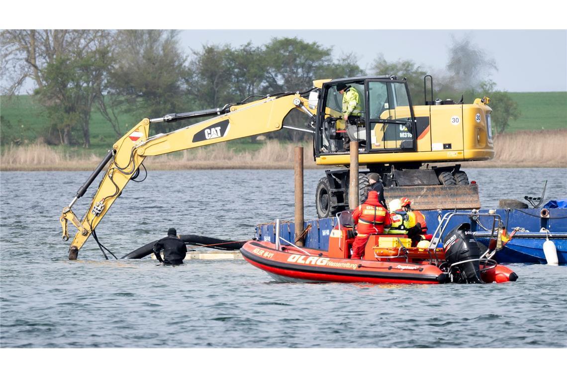 Helfer einer privaten Initiative graben eine Rinne vom Liegeplatz des gestrandeten Wals zum tiefen Fahrwasser.