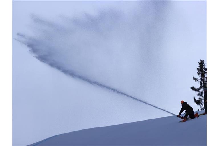 Helfer präparieren die Kandahar-Abfahrt mit Wasser um den, wegen der milden Temperaturen zu weichen Schnee, zu vereisen. Foto: Karl-Josef Hildenbrand/dpa