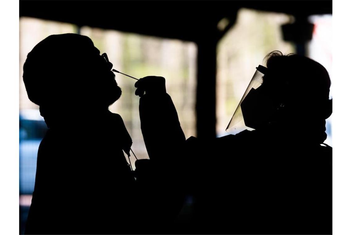 Bundesweite 7-Tage-Inzidenz nähert sich der 100 Helfer testen einen Mann im „Testzentrum am Zoo“ in Hannover mit einem Schnelltest auf das Coronavirus. Foto: Julian Stratenschulte/dpa